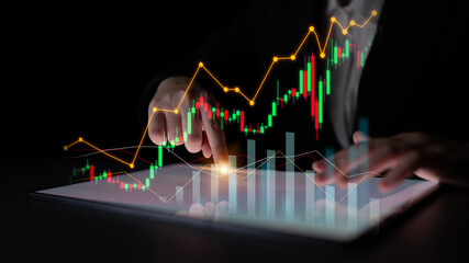 A business professional engages in financial analysis using a digital tablet to explore stock market trends, detailed graphs, and dynamic data in a sleek environment. Scalp
