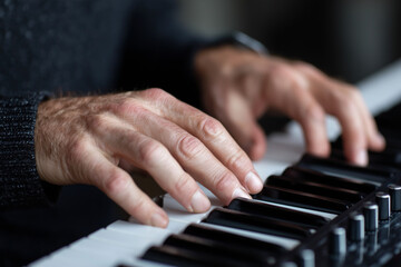 Fototapeta premium A man is playing a piano with his hands