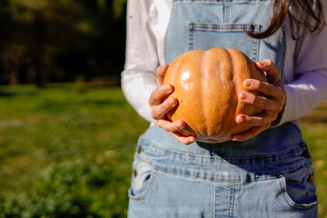 Unrecognizable Woman Preparing Halloween with a pumpkin