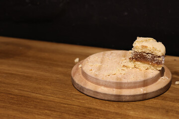 A piece of cornstarch alfajor on a wooden tray
