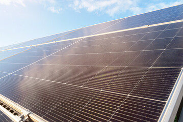 Close-up of photovoltaic solar panels producing renewable energy under bright daylight sky