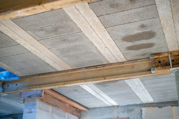 Construction process: installation of beam-and-block floor system on prestressed beams. Bottom view. Concept of strength, engineering precision, and technology.