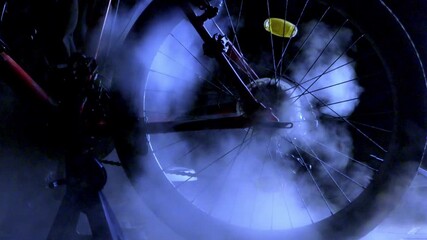 Steam cleaning a mountain bike. Post-season bike maintenance and use. Preparing your bike for the season. Bicycle service. A rear bicycle wheel bathed in a cloud of steam while being pressure washed.