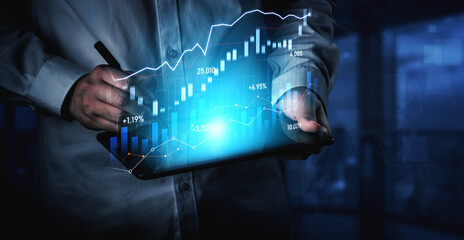 An engaged businessman analyzes financial data on a digital tablet, highlighting graphs and charts in a modern office setting with a blue color theme, showcasing trends. Scalp