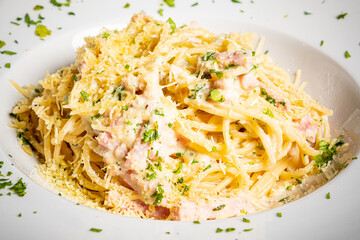 Savor rich spaghetti carbonara topped with herbs and cheese for a comforting meal