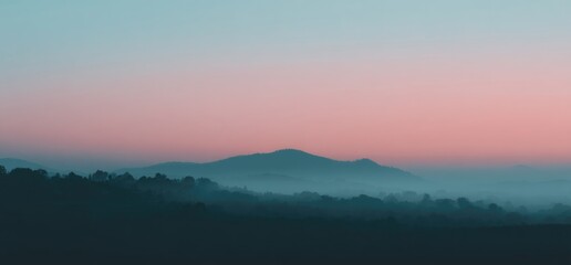 Misty mountains at dawn under a pastel sky