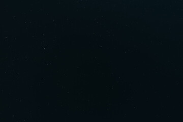 A calm, clear night sky filled with countless tiny stars, fading gently toward the horizon in a serene and peaceful celestial view.