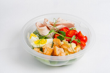 A vibrant salad bowl features mixed greens, cherry tomatoes, turkey, croutons, and egg