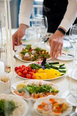 A chef creates a vibrant array of fresh salads and colorful dishes for guests