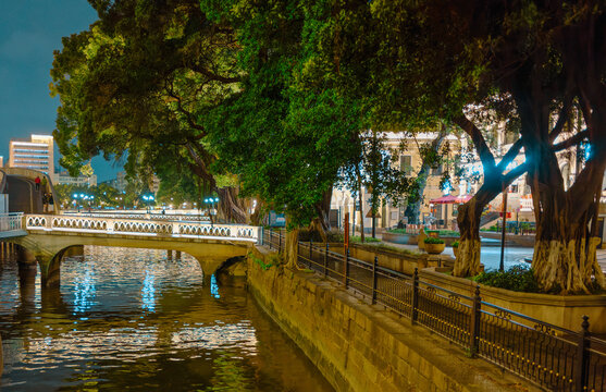 Guangzhou, Canton, China : Night view of the Lizhiwan or Liwan Canal in Guangzhou, Canton, China. Illuminated old stone bridges. Banyan or banian trees on the banks. Buildings.