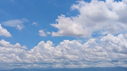 Fototapeta premium Natural landscape with fluffy white clouds under blue sky.
