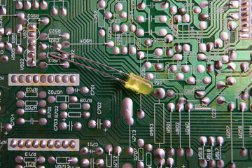 Isolated single yellow led on the electronic circuit board.