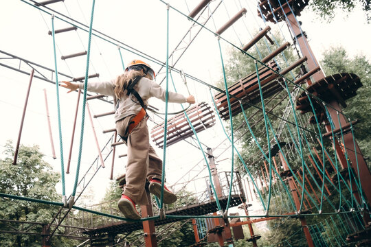 Child Navigates High Rope Course with Safety Gear
