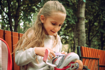Child Putting on Roller Skates Outdoors