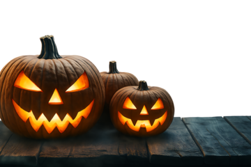Scary Halloween Jack-o'-lantern pumpkins with glowing evil faces on a wooden table. Spooky holiday decoration, isolated on a transparent background with copy space.