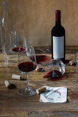 A gourmet wine tasting scene with a bottle of red wine, glasses, cheese, and appetizers on a rustic table.