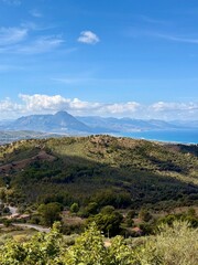 Mountainous central Sicilian landscape near Campofelice di Roccella, Italy, featuring rolling hills, distant Tyrrhenian Sea views, and the volcanic Islands on the horizon under
