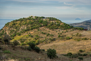 Mountainous central Sicilian landscape near Campofelice di Roccella, Italy, featuring rolling hills, distant Tyrrhenian Sea views, and the volcanic Islands on the horizon under