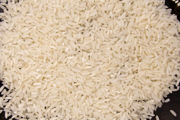 Large rice grains scattered in a black surface