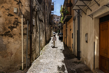 Fototapeta premium View of Isnello, a historic Sicilian mountain town in the Madonie Mountains, featuring charming narrow streets, traditional stone houses, and a Gothic church, Sicily, Italy. Italian town in hills