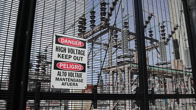 danger high voltage keep out sign in front of outdoor power plant in brooklyn new york (electricity generation transformer station electric current warning) fence alternating direct electrical grid