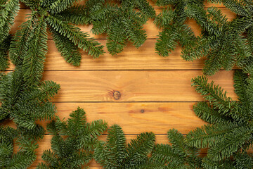 Christmas tree branches on wooden background, top view