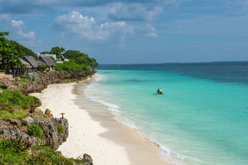 Traditional wooden dhows anchored near the shore in Nungwi, Zanzibar, with turquoise waters and clear skies. Idyllic tropical seascape and cultural heritage.