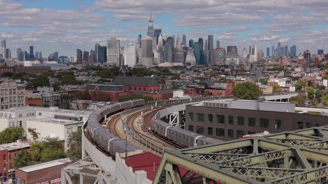 elevated subway trains cross in Brooklyn in front of downtown NYC skyline