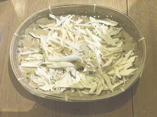 Dried Wood Shavings in Traditional Bamboo Basket on Wooden Table