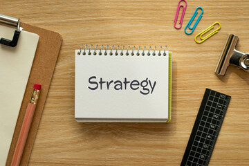 There is notebook with the word Strategy. It is as an eye-catching image.