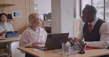 Multicultural team collaborates on a project in a startup business office. Diverse colleagues work together, demonstrating teamwork and communication. - Powered by Adobe