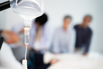 Closed up hanging saline solution bottle in emergency room at hospital, drop of saline for medical...