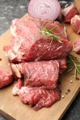 Pieces of raw beef meat and spices on table, closeup