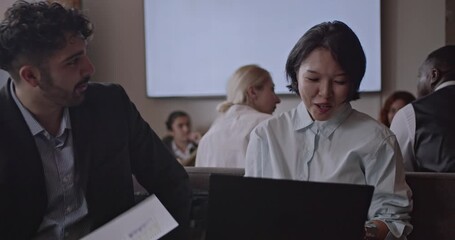 Multicultural business team collaborates on a project, discussing data and strategies in a modern office environment. - Powered by Adobe