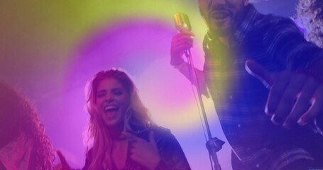 Singing band members performing on stage, with vintage microphone, colored lights and haze