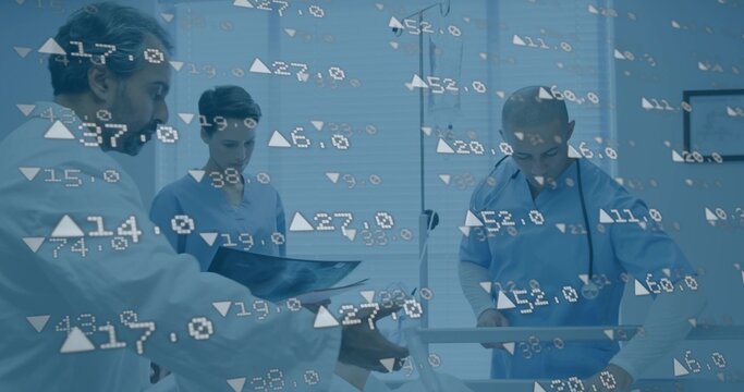 Collaborating staff in scrubs reviewing patient data at hospital bed, with digital overlays