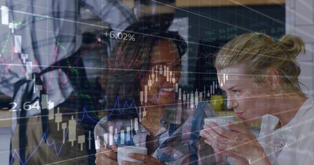 Chatting business casual colleagues at office over coffee mugs by laptop, overlaying stock charts