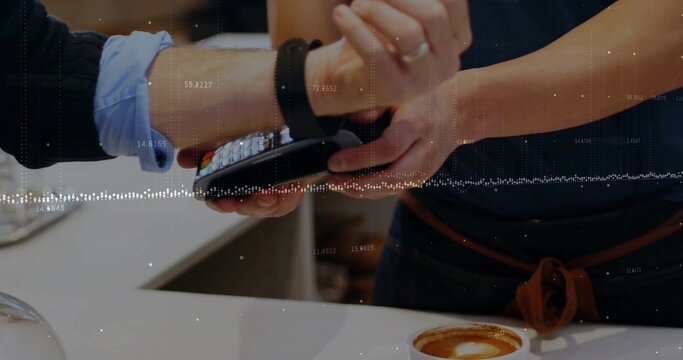Tapping smartwatch on handheld POS terminal at coffee shop counter, showing latte foam art