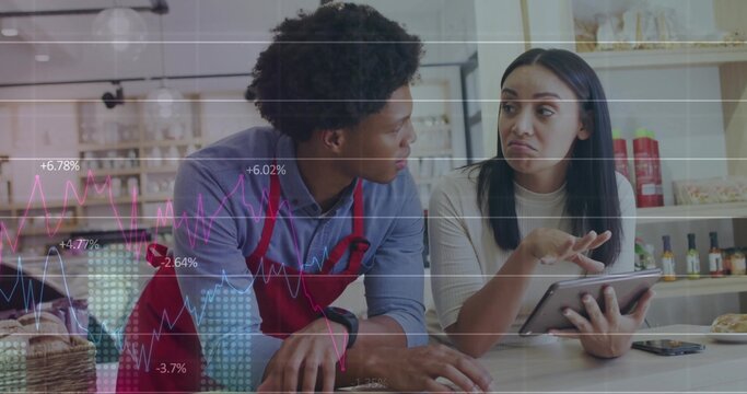 Reviewing sales figures, staff analyzing tablet at cafe counter, with pastry basket, smartphone