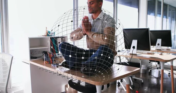 Man sitting cross legged on business desk praying and materializing wireframe sphere for meditation