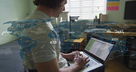 Mid adult man typing on laptop in home office, animating global map for real-time data analysis - Powered by Adobe