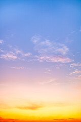 Sunset or sunrise sky with a vibrant gradient of orange, gold, and soft blue. Clear atmosphere with wispy clouds. Peaceful, natural light background. hope, freedom, new day Concepts, Vertical