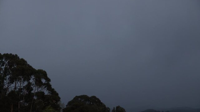 timelapse of sunrise and moon setting over snowy tasmanian mountains with gum trees
