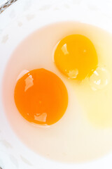 Duck egg yolk and chicken egg yolk together in one bowl on white background