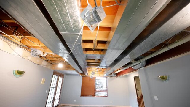 hvac heating, ventilation, air conditioning system under the ceiling in the empty basement room in residential house under renovation. Dolly in camera move