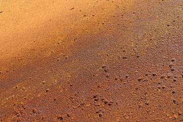Rusty metal background in brown, red and orange colors. Rusty métal with particles and texture. Grainy rust and construction industry. Canvas and pattern in metallic texture.	