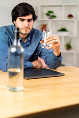 Young man coping with problems drinking alcohol at home
