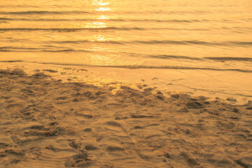 A beach in Indonesia, with the sea turning gold at sunset, background of the beach in the evening