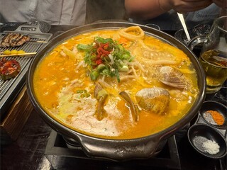 Spicy seafood hot pot with clams, vegetables, and broth