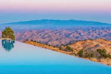 Elevated pool reflects mountain vista at dawn